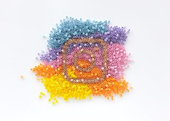 Instagram logo made of rainbow coloured pyssla beads blue purple pink orange yellow white background