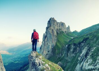 Tourist on a rock in Switzerland. Active rest and tourism in summer time.