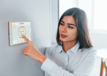 Woman is indoors controlling smart home technology
